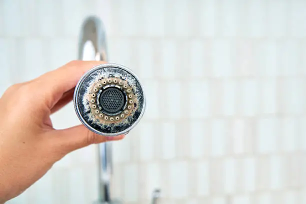 How to Confirm Hard Water vs Cleaning Issues White crusty mineral buildup and chalky limescale deposits on a chrome bathroom faucet fixture, showing clear signs of hard water damage.